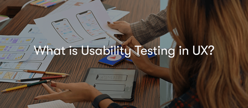 two people looking at piece of paper with UX design layouts on them, with the text what is usability testing in UX? in front